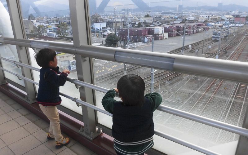 新居浜駅の歩道橋から電車を見る子供